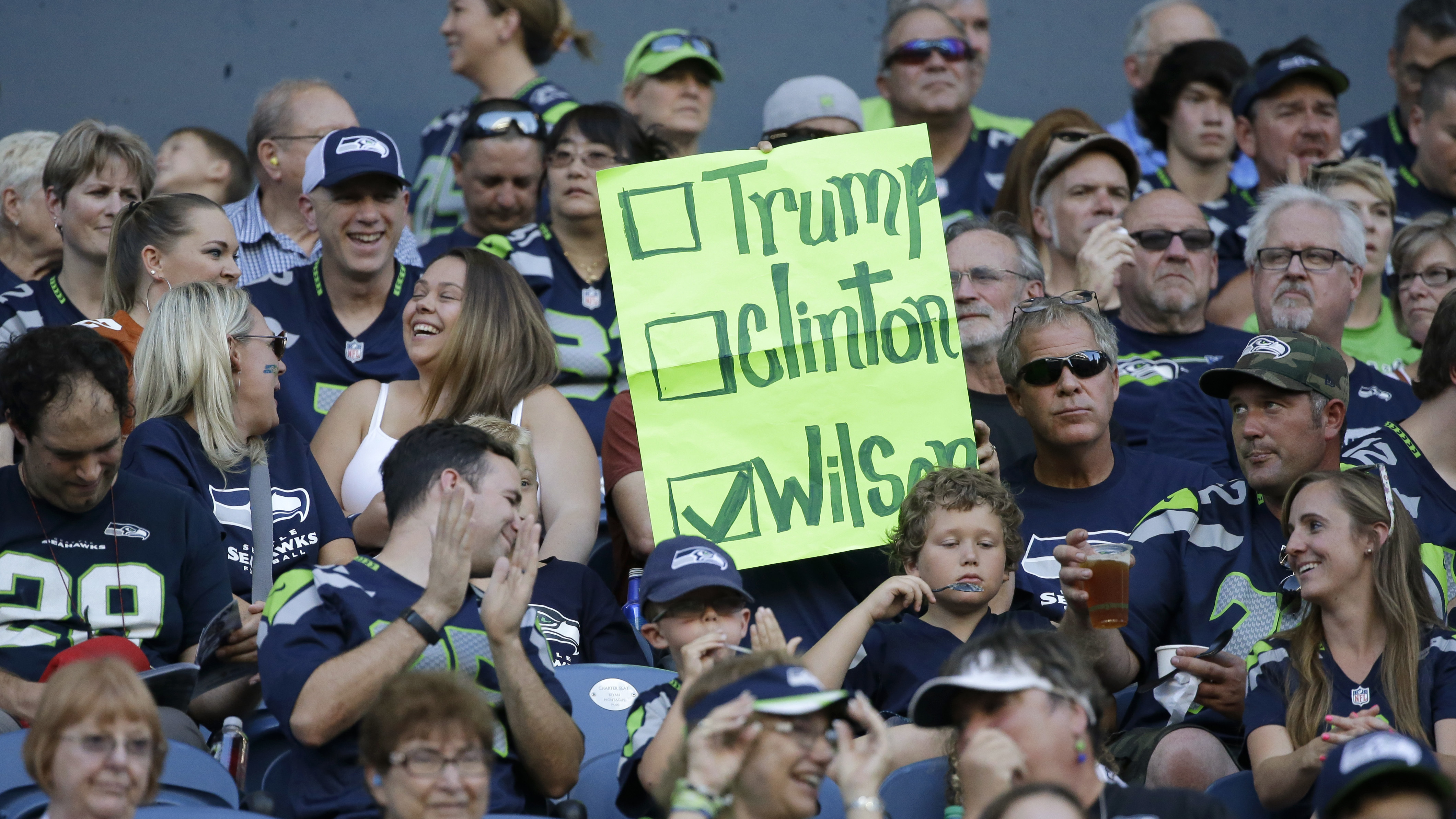 A Seattle Seahawks fan holds a sign suggesting quarterback Russell Wilson for president instead of Hillary Clinton or Donald Trump